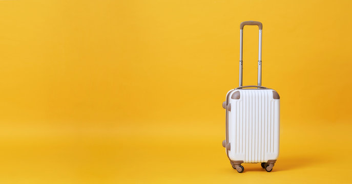 White luggage bag isolated on yellow banner background with copy space for advertisement..