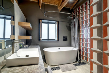 Luxury bathtub with a wall full of modern tiles in a bathroom