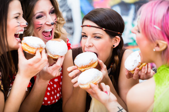 Girls at German Fasching Carnival eating doughnut-like traditional pastry