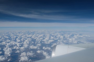 View of white clouds and blue sky from airplane
