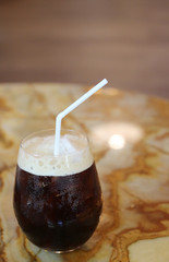 Black coffee with ice on table in cafe.