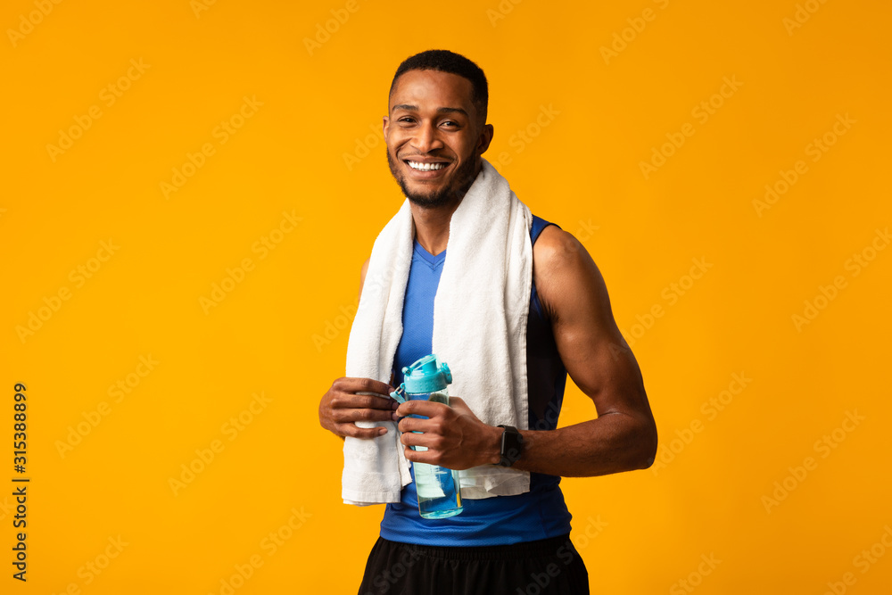 Poster Handsome afro sportsman holding water bottle copyspace