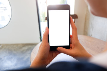 Mockup picture of business man's hands or woman’s hands holding smart phone with white blank screen in modern place.