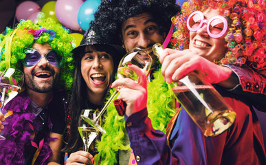 Happy girls and boys at Carnival Party clinking glasses with champagne.