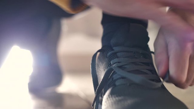 Jogger tying sneaker shoelaces before running