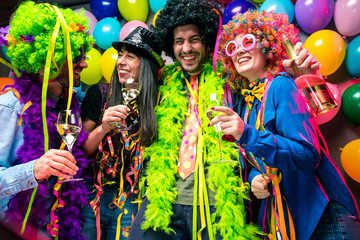 Happy girls and boys at Carnival Party clinking glasses with champagne.