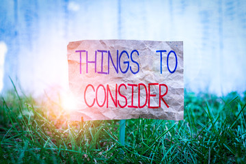 Word writing text Things To Consider. Business photo showcasing think about carefully especially in making decisions Crumpled paper attached to a stick and placed in the green grassy land