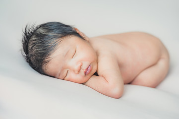Fototapeta na wymiar Asian newborn baby sleeping on bed