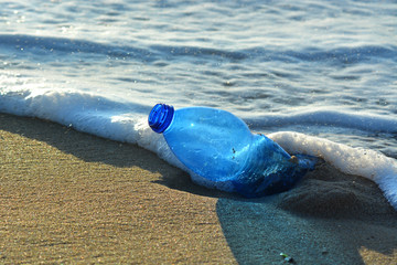 Plastic bottle pollution on a sandy beach.