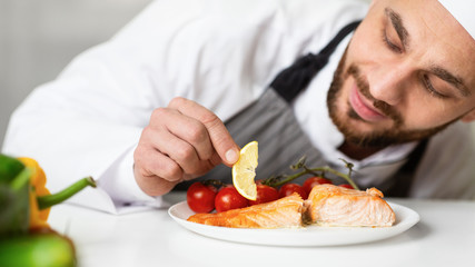 Chef Plating Roasted Fish Dish Decorating Food In Restaurant Kitchen