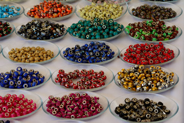 Different color jewelry beads on glass plates