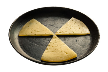 Slices of cheese in a black cast-iron frying pan. Isolated on a white background