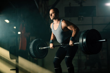 Fototapeta na wymiar Muscular build man having weight training in a gym.