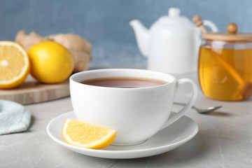 Obraz na płótnie Canvas Fresh tea with honey and lemon on light grey marble table, closeup