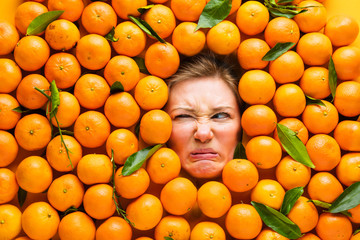 Food industry. Face of funny young woman in orange or Mandarin plane.