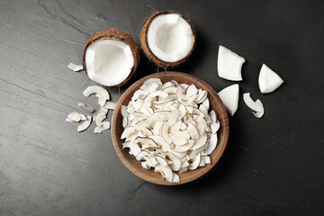Flat lay composition with tasty coconut chips on black  table