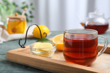 Delicious tea with honey, ginger and lemon on tray