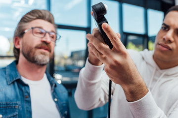selective focus of photographer holding light meter near art director