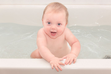 Little baby boy in the bathtub full with water 