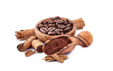 Coffee beans with cinnamon in wooden bowl isolated on white background.