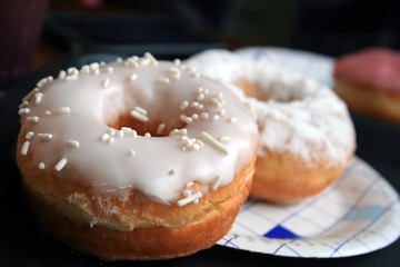 Sweet lush donuts in white sugar glaze closeup. Selective focus