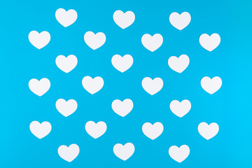 A group of white hearts placed on the blue background like a chessboard pattern