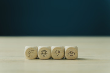 Four wooden dices with contact and information icons