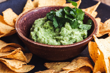 Mexican traditional food, guacamole sauce, ingredients  avocado, cilantro, lime and tortilla corn chips