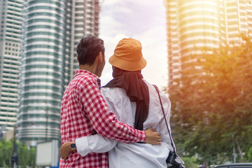 Tourist couple at Kuala Lumpur smiling looking at the modern building