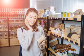 Woman chooses and buys products in zero waste shop.