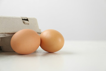 Raw brown chicken eggs on white table