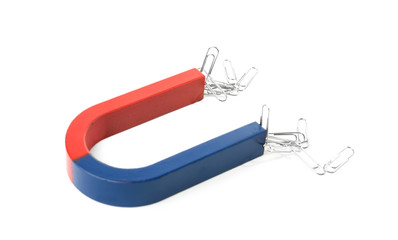 Magnet attracting paper clips on white background