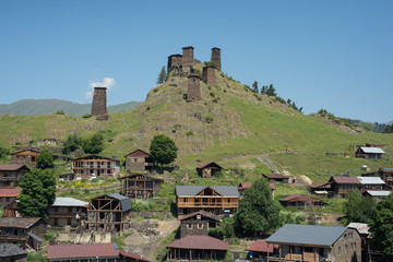 From below solitary ancient tower with stone walls at outskirts of village against amazing view of green forested hills and misty valley in Georgia