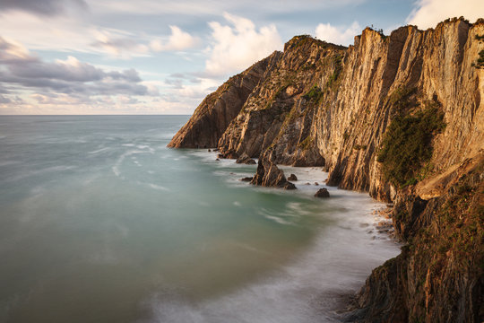 From above scenic peaceful seashore with calm azure waves in light of setting sun on rocky beach of Silence O Gaviero