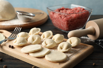 Composition with minced meat and dumplings on wooden background, close up