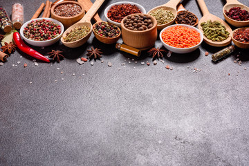 A set of spices and herbs. Indian cuisine. Pepper, salt, paprika, basil and other on a dark background