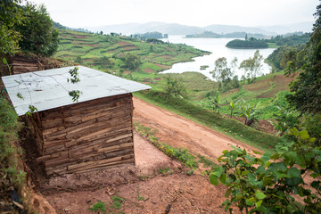 Uganda - November 26, 2016: From above magnificent scenery of countryside with small cultivated fields and solitary village among hills with green lush grass and dense forests
