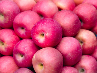 Fresh pink apples sale on the market or in the supermarket. Red apples background. Fruits and vegetables image.