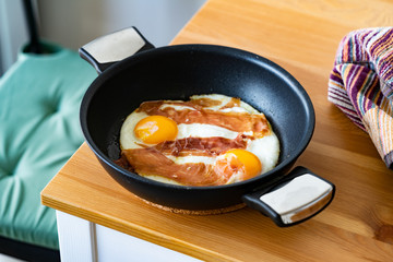 Fried Eggs with Prosciutto in Pan for Breakfast. Ready to Eat.