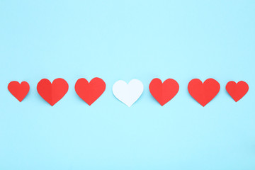 Red and white paper hearts on blue background