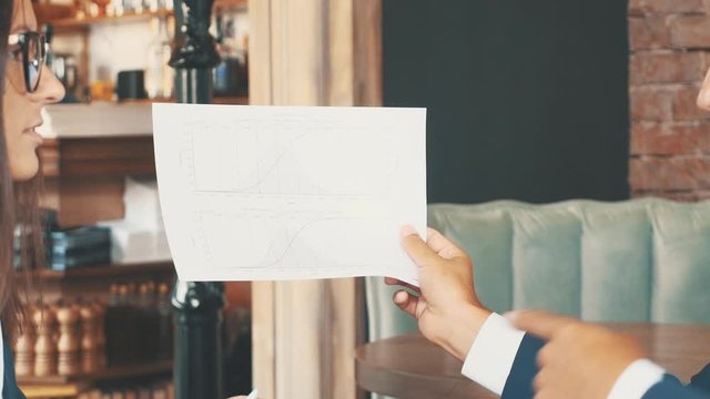 Two businesspeople are discussing the important information, showing diagram. Crop. Close up. Copy space.
