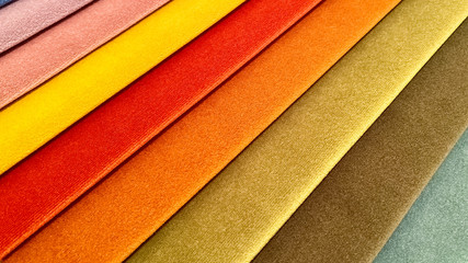 Perspective of a palette of fabric samples of multi-colored shades. Background, texture