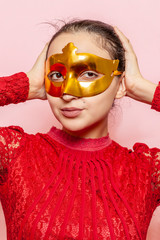 Portrait of beautiful woman in evening dress and golden masquerade mask. Valentines day, Carnival, Festive Ball, Birthday celebration concept. Facial expressions of young female