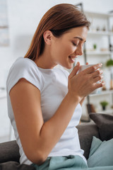 young attractive woman with closed eyes holding cup with tea