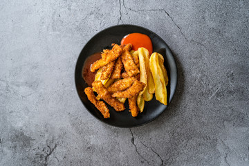 Fish and Chips made with Breaded and Fried Seabass in Black Plate.