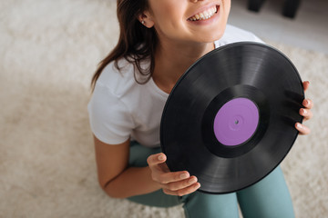 cropped view of happy woman holding retro vinyl record
