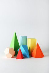 Colorful paper geometric figures on grey background