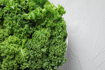Fresh kale leaves on white table, top view. Space for text