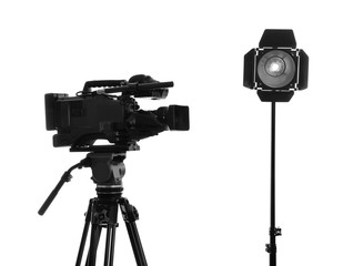 Professional video camera and lighting equipment isolated on white