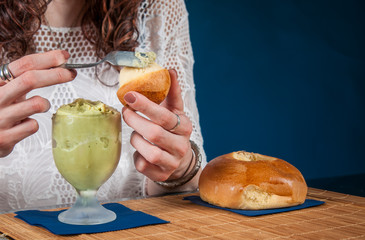 Feel of freshness: girl eating a typical sicilian pistachio granita with a warm brioche